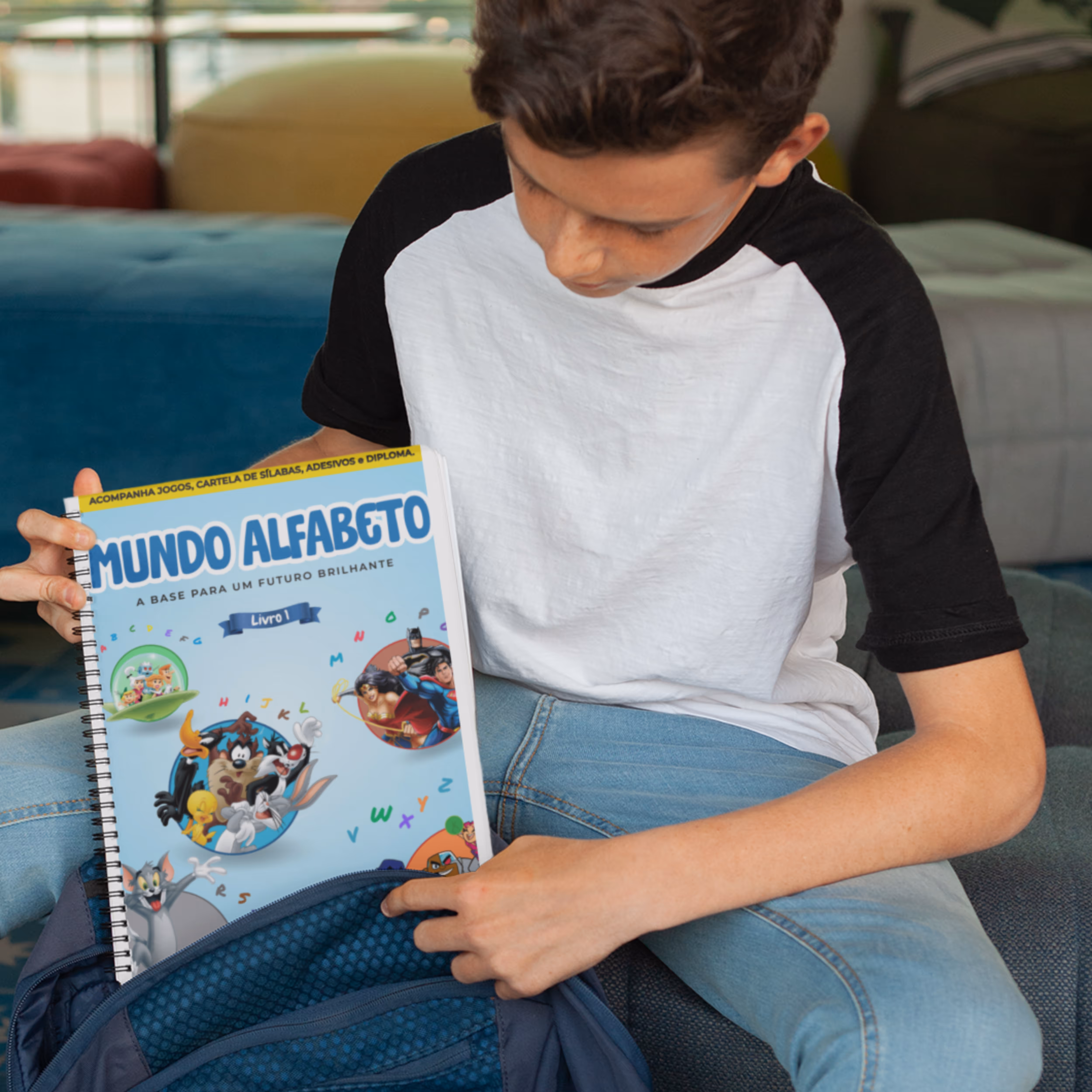 Criança segurando um livro educacional do mundo alfabeto da editora fundamento